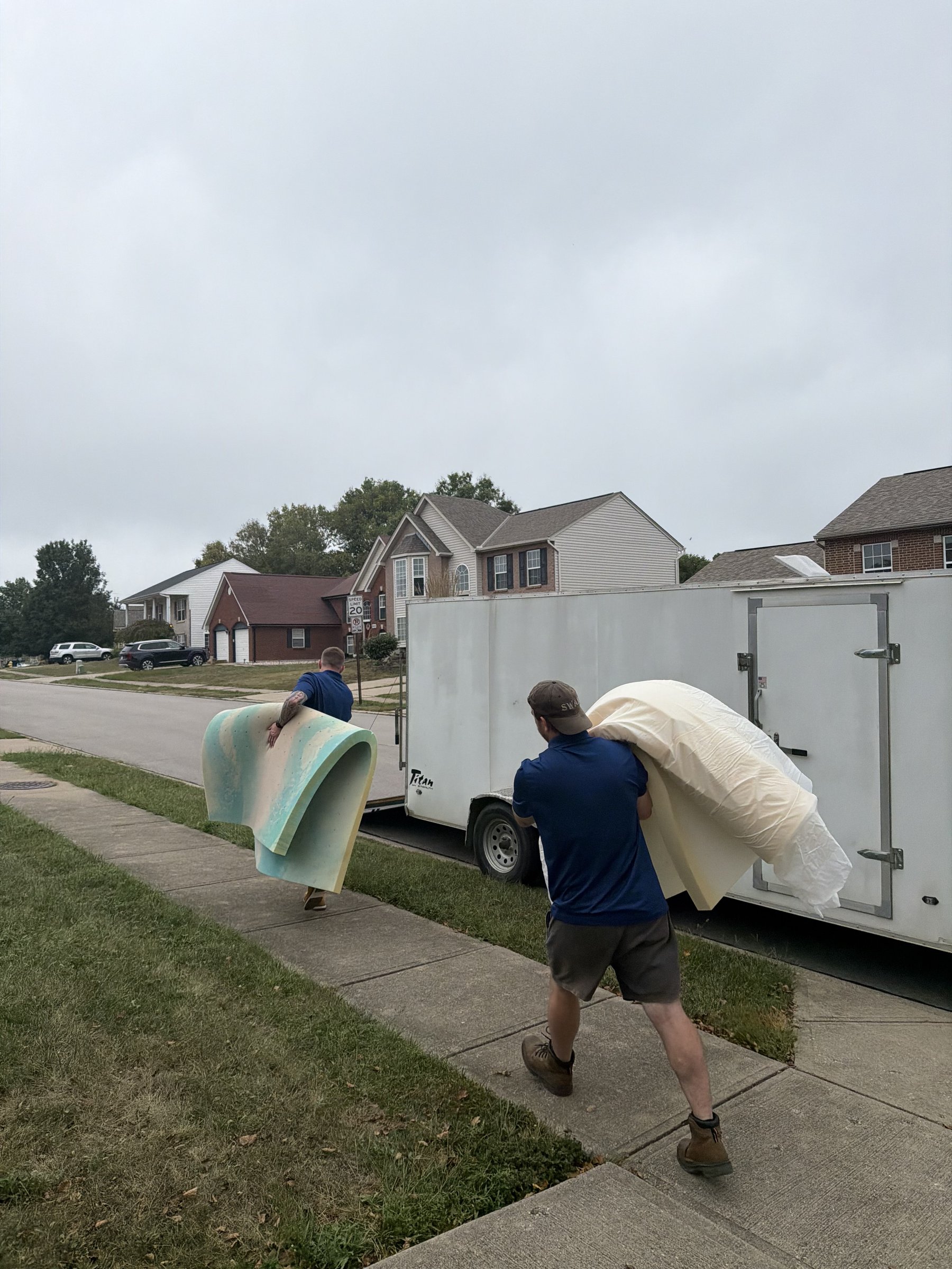 Junk Dads crew carrying bulky furniture to their trailer