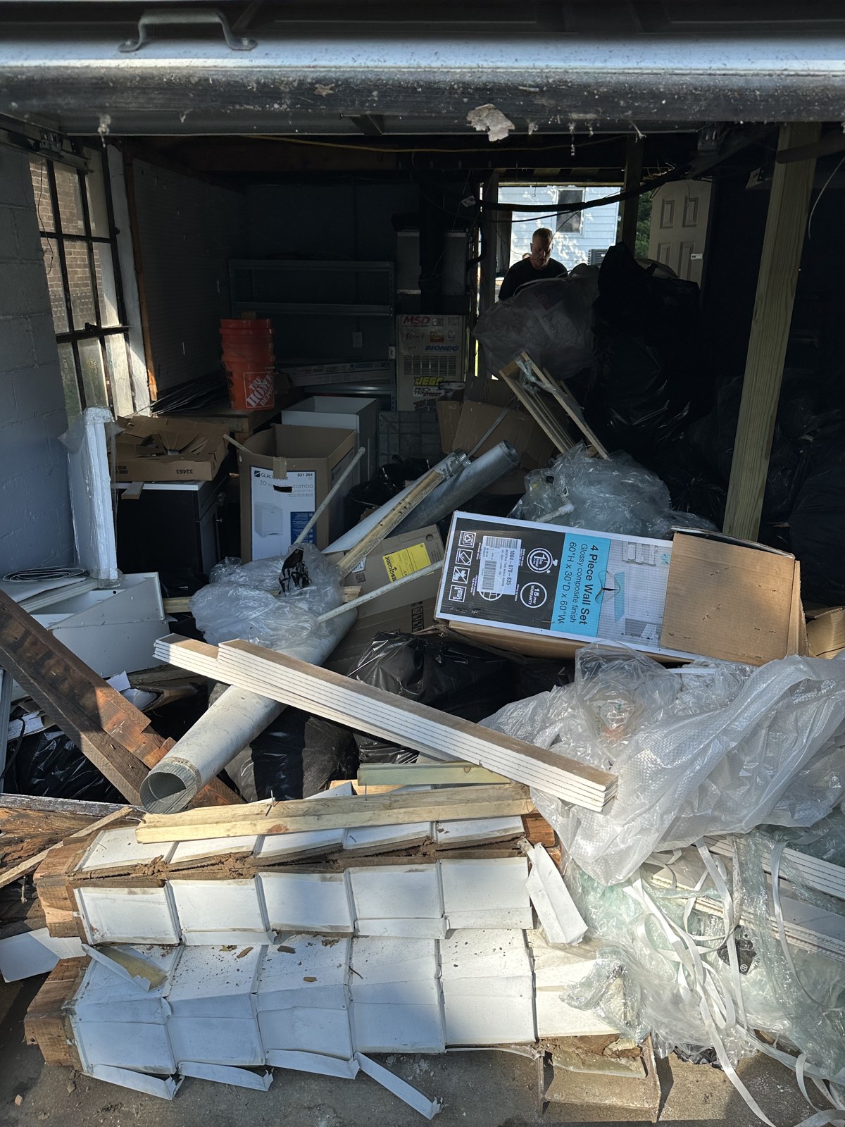 Loaded garage bay full of siding, lumber and packaging ready to be cleared out