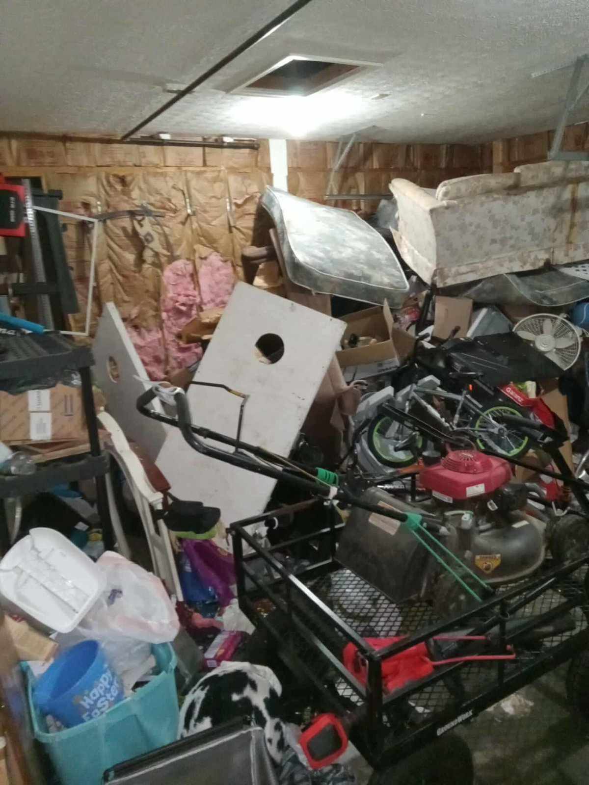 Garage packed wall to wall with furniture, bikes and bins before a whole house clean out